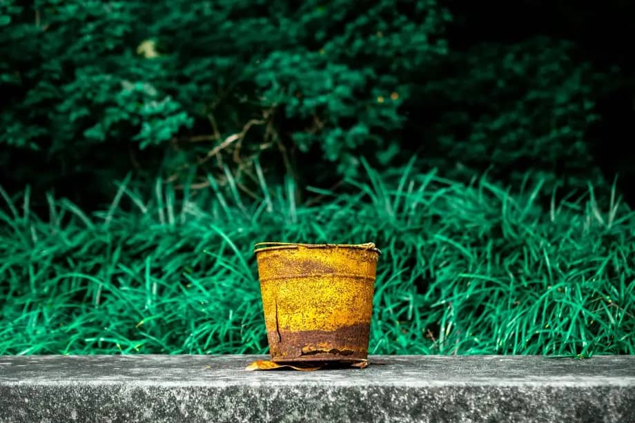 yellow bucket sitting on a wall