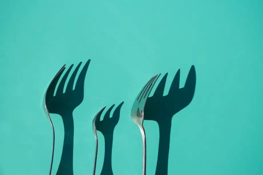forks with shadows on green wall