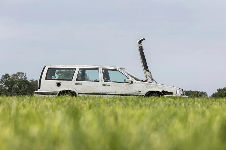 car with bonnet up in field